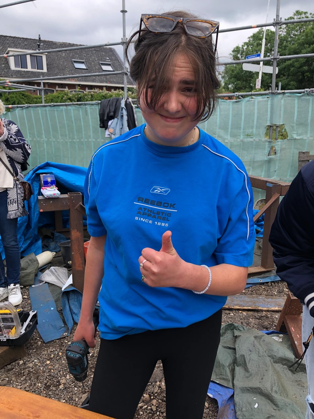 Thumbs up with a drill in hand at the boat yard