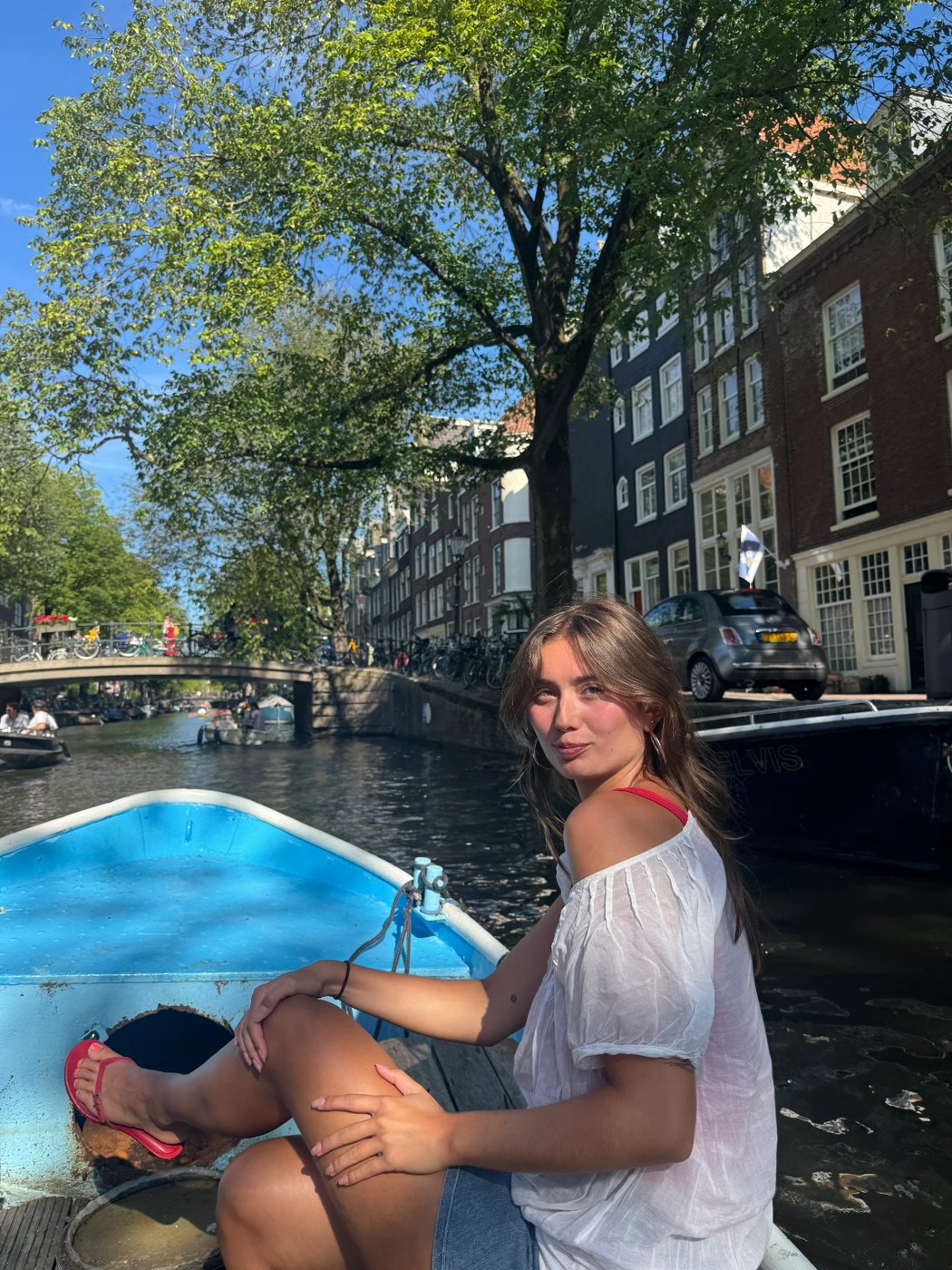 Sitting on the bow of a blue boat on a bright summer day